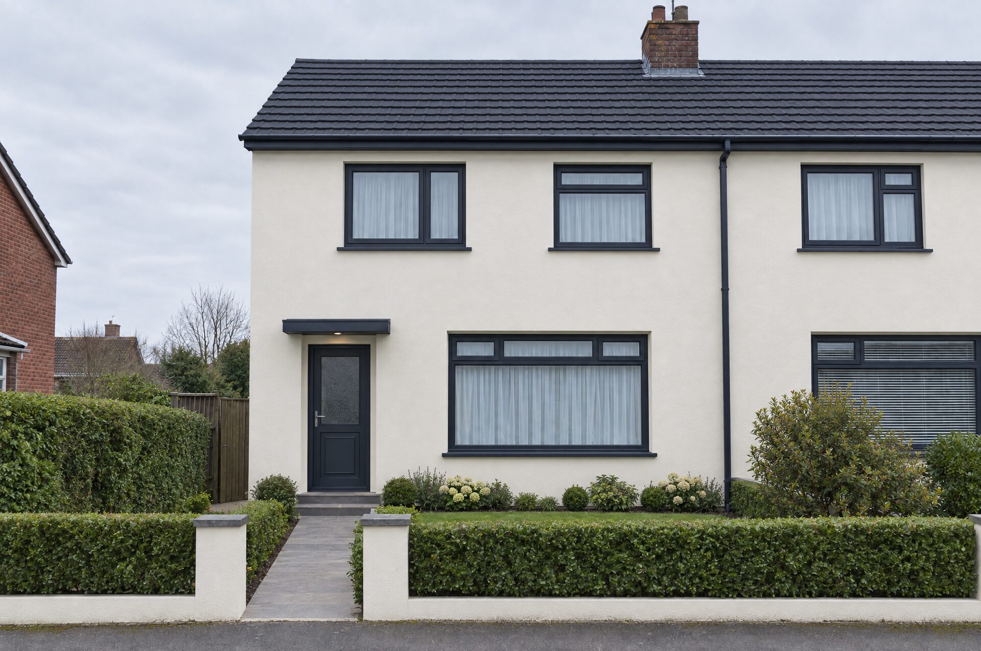 The same house after external wall insulation, with a smooth off-white render facade, new windows and a new roof